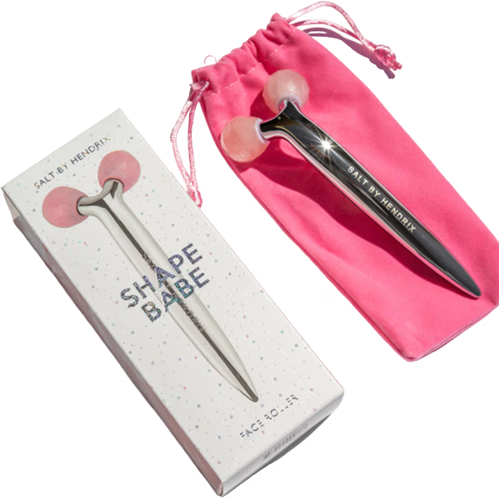 Facial roller with packaging and pink pouch on a white background