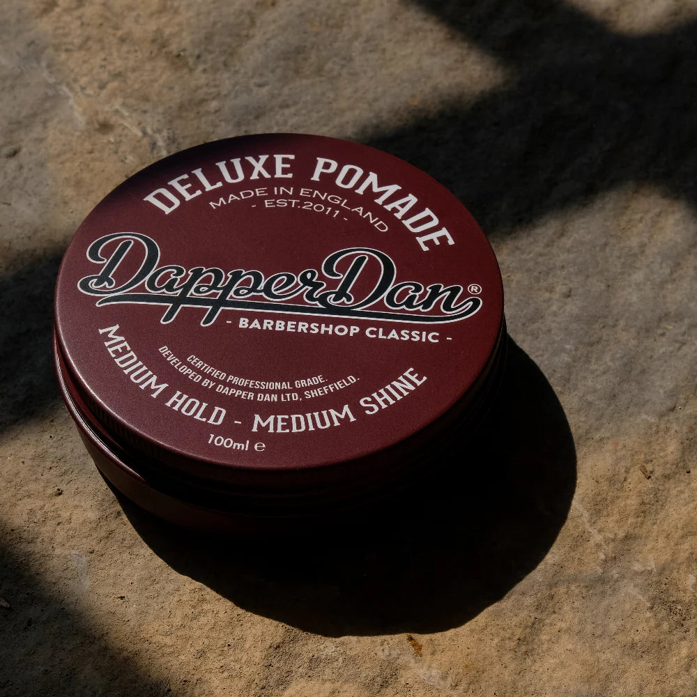 Dapper Dan pomade container on a stone surface
