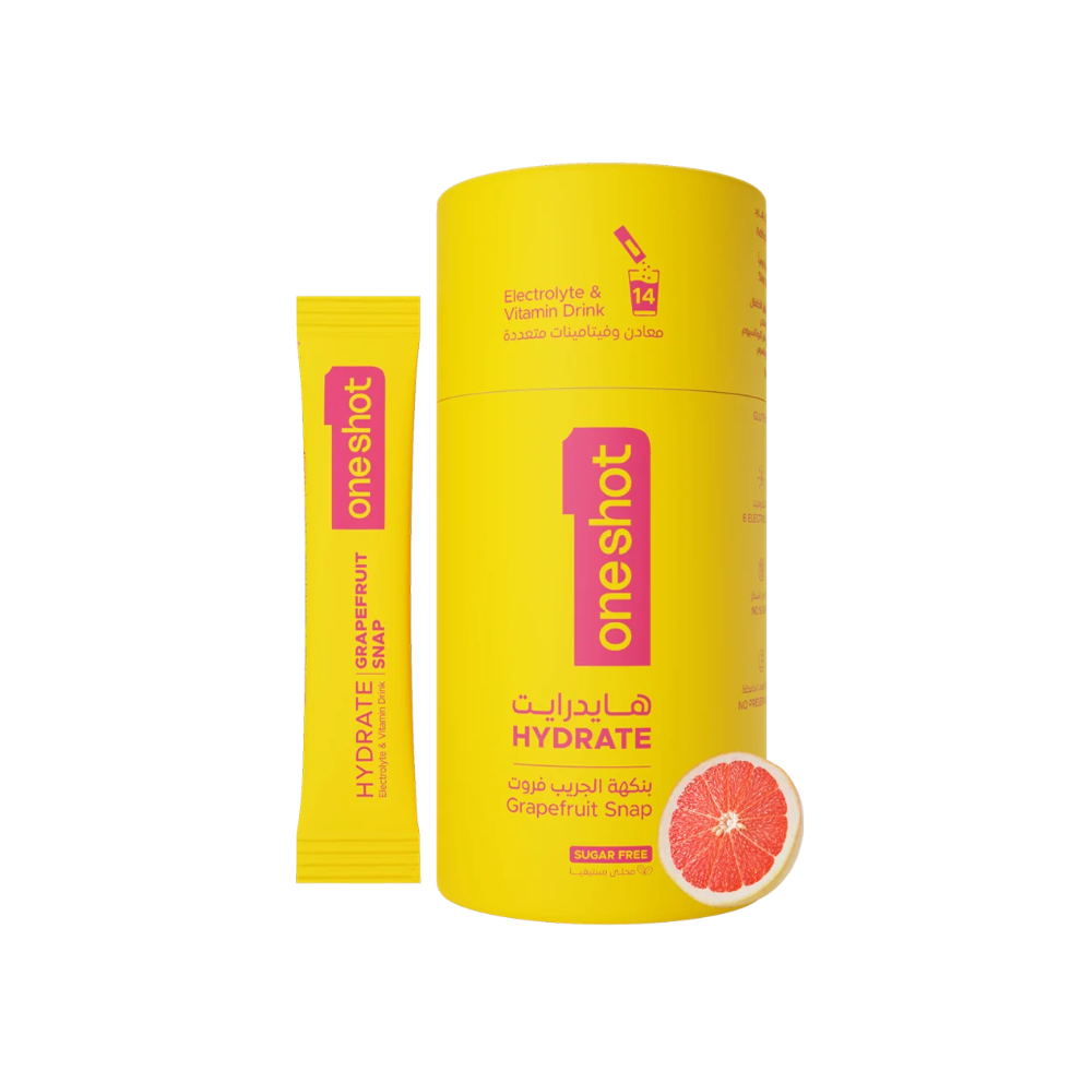A yellow OneShot Hydrate grapefruit snap stick pack and its matching yellow cylindrical container with Arabic text and a grapefruit slice graphic, shown on a white background.