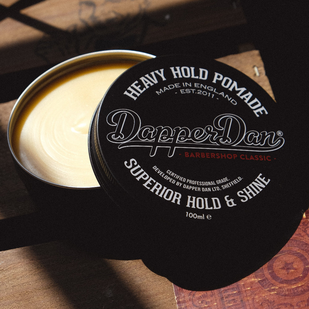 Dapper Dan heavy hold pomade container on a wooden surface