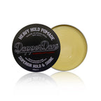 Dapper Dan heavy hold pomade container with black lid and gold body on a white background