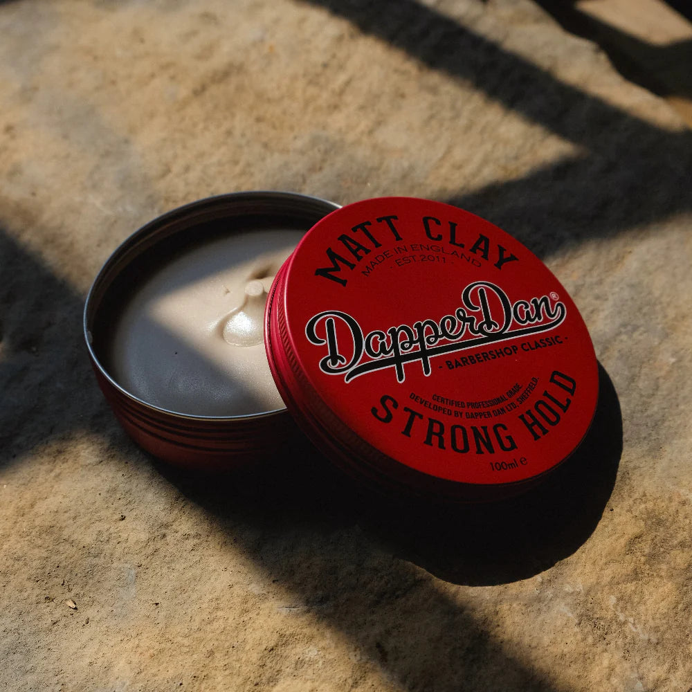 Red container of Dapper Dan Matt Clay on a stone surface