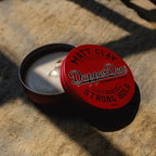 Red container of Dapper Dan Matt Clay on a stone surface