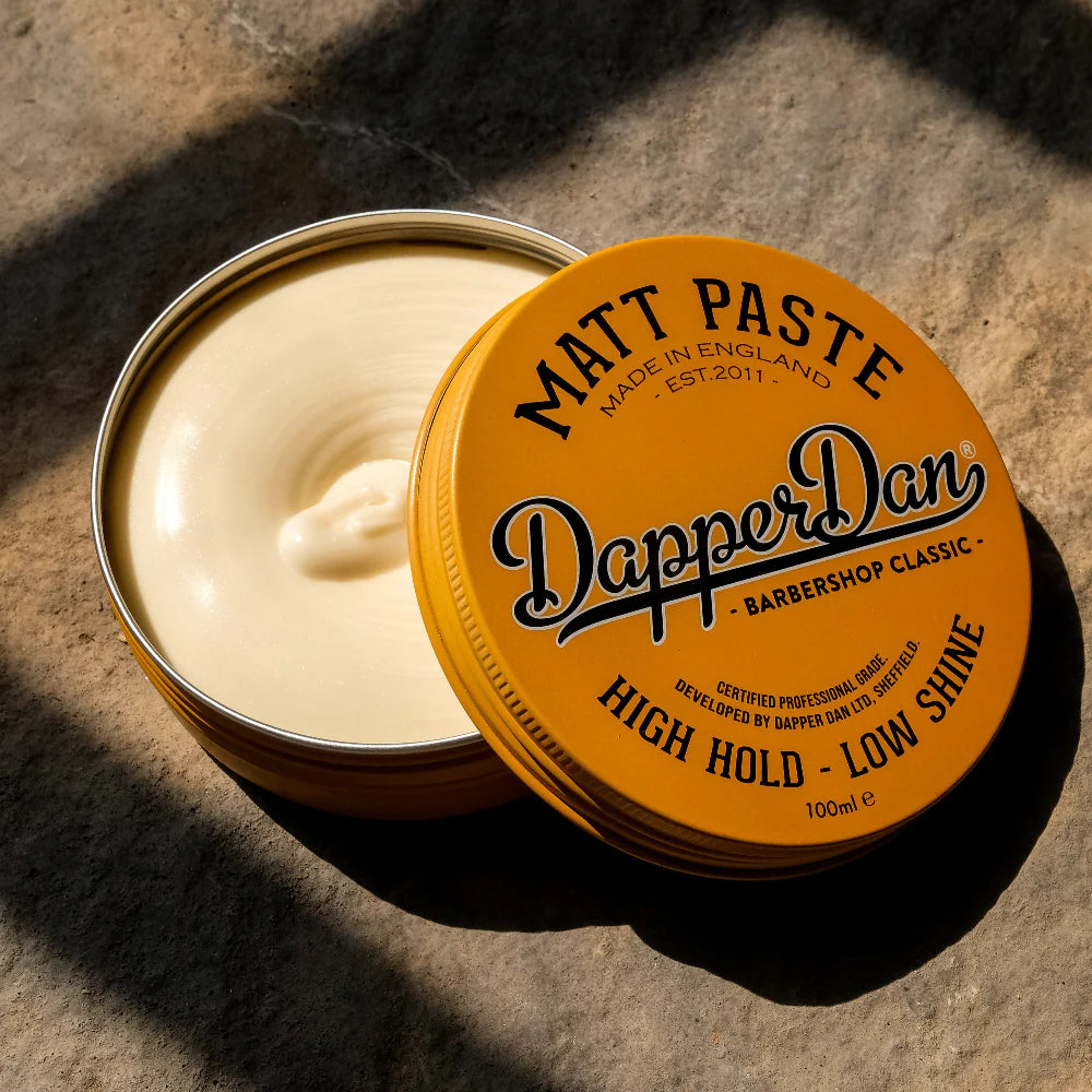 Dapper Dan Matt Paste container with open lid on a textured surface