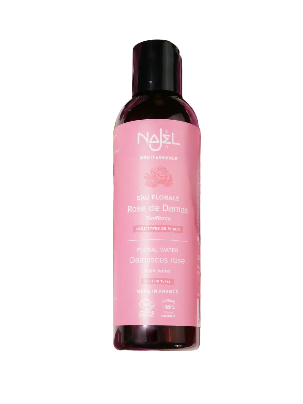 Nuxe bottle with pink label surrounded by flowers on a light background
