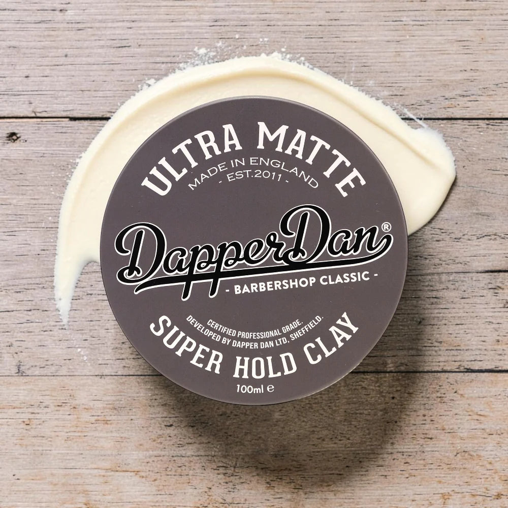 Dapper Dan Ultra Matte Super Hold Clay container on a wooden surface