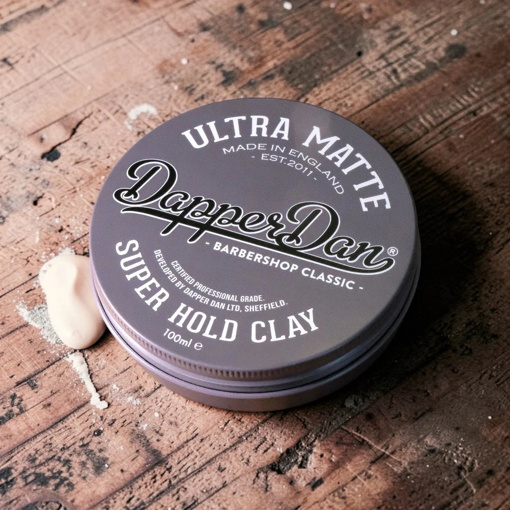 Dapper Dan Ultra Matte Super Hold Clay container on a wooden surface