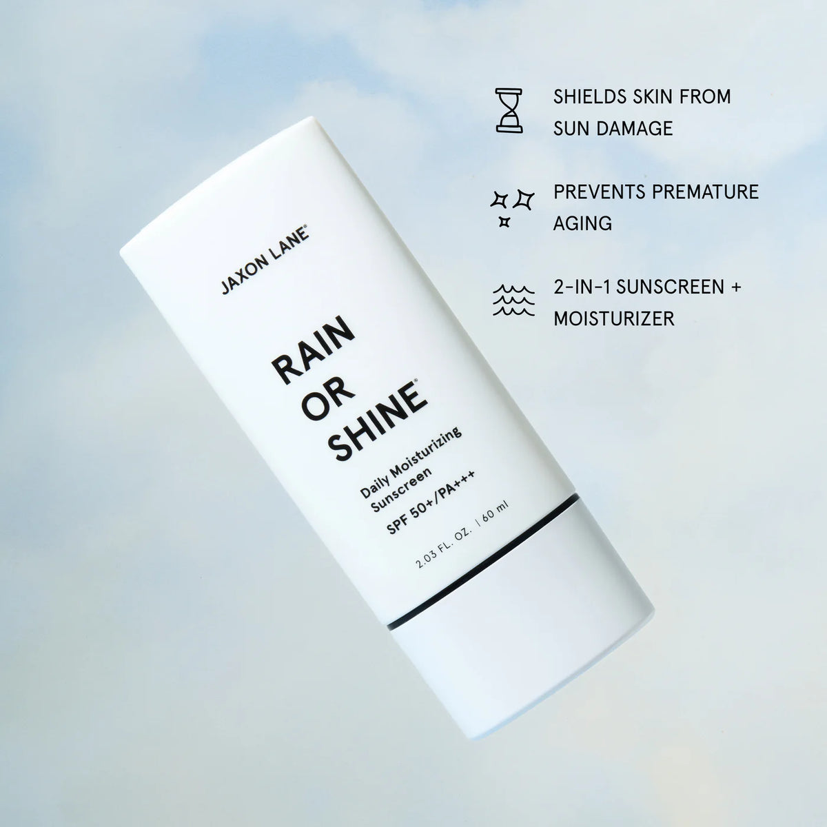 Jaxon Lane Rain or Shine Daily Moisturizing Sunscreen SPF 50+ / PA+++ in a white squeeze tube, shown on a soft light blue background with black text callouts about sun damage, aging prevention, and dual sunscreen moisturizer benefits.