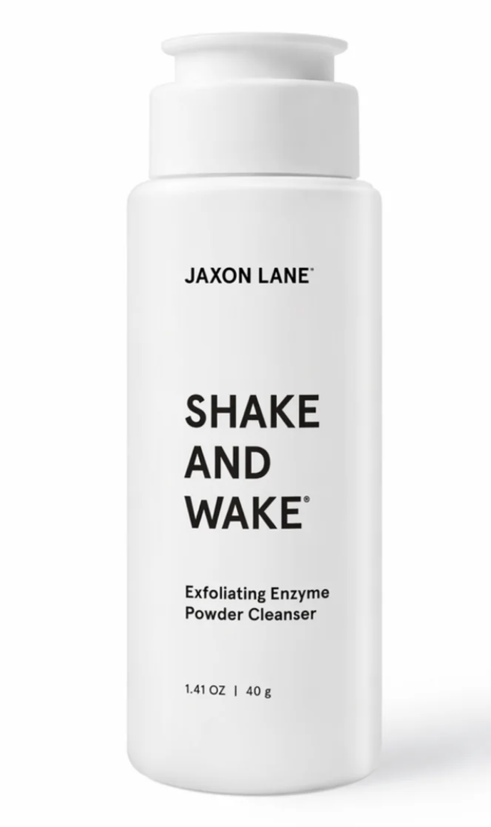A white cylindrical pump bottle of Jaxon Lane Shake and Wake Exfoliating Enzyme Powder Cleanser on a clean white background.