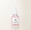 A pink glass dropper bottle of Pure Firming Serum with a white label and white dropper cap, centered on a clean off-white background with a soft reflection below.