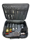 Open grooming kit with scissors, clippers, and other tools inside a black case on a white background