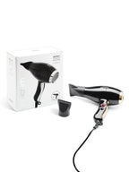 Black hair dryer with gold accents next to its packaging on a white background