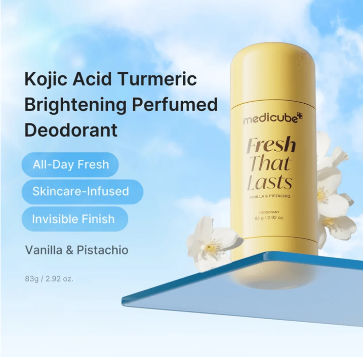 A yellow Medicube Fresh That Lasts deodorant stick on a blue floating platform against a sky-blue background with clouds and white flowers. Text on the left reads 'Kojic Acid Turmeric Brightening Perfumed Deodorant' and 'Vanilla & Pistachio'.